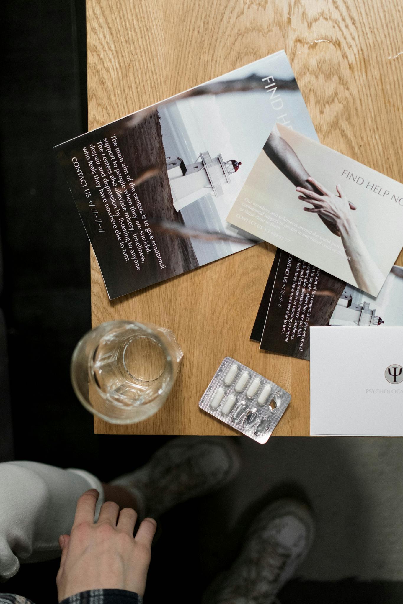 Top view of mental health pamphlets and medication on a table, symbolizing support and awareness.